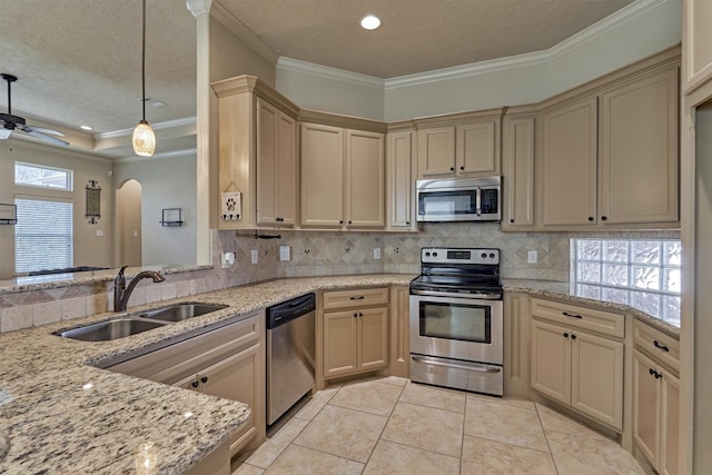 kitchen featuring pendant lighting, sink, appliances with stainless steel finishes, tasteful backsplash, and ornamental molding