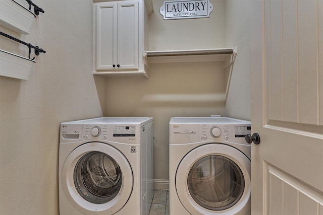 clothes washing area featuring cabinets and washing machine and dryer