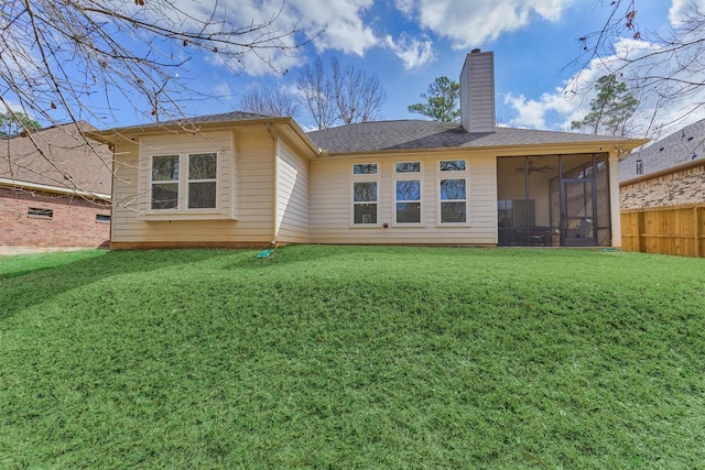 back of property featuring a sunroom, ceiling fan, and a lawn