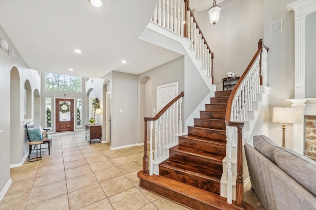 tiled foyer with a towering ceiling