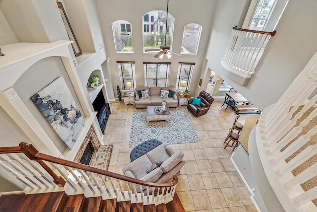 living room featuring light tile patterned floors, a towering ceiling, and ceiling fan