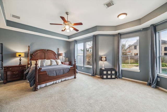 carpeted bedroom with multiple windows and ceiling fan