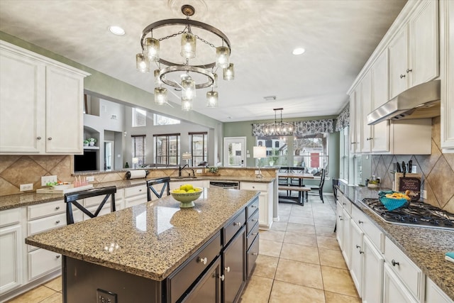 kitchen featuring an inviting chandelier, decorative light fixtures, white cabinets, and a kitchen island