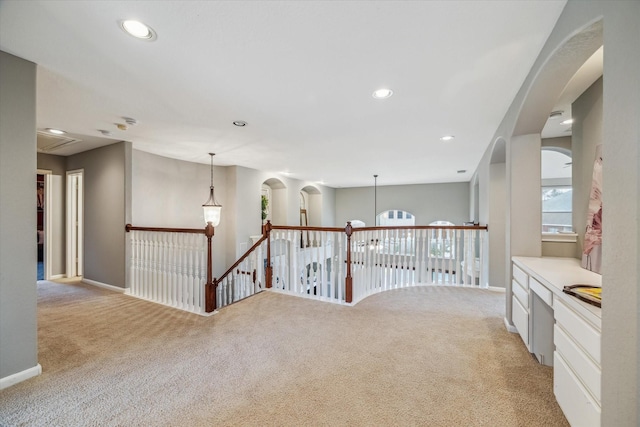 hall with light colored carpet