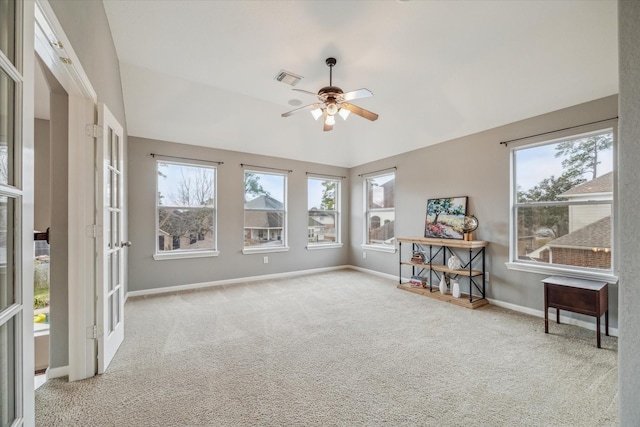 interior space featuring a wealth of natural light, vaulted ceiling, light colored carpet, and ceiling fan