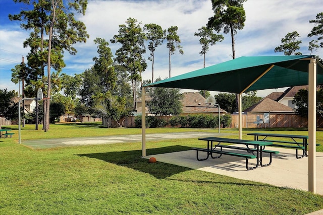 surrounding community featuring a yard and basketball hoop