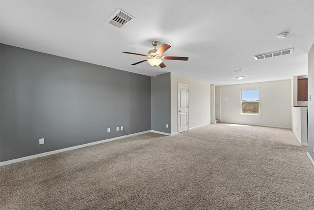 spare room with carpet, visible vents, ceiling fan, and baseboards