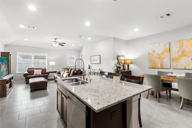 kitchen featuring visible vents, open floor plan, a sink, a kitchen island with sink, and stainless steel dishwasher