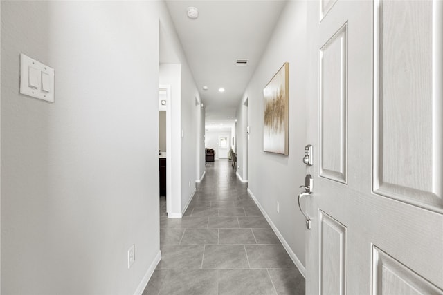 hall featuring recessed lighting, light tile patterned flooring, and baseboards