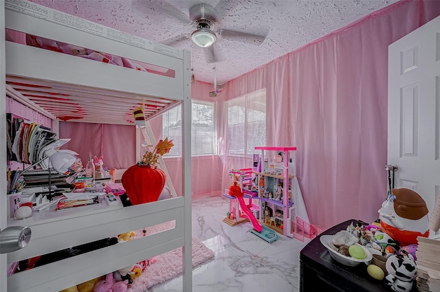 bedroom with a ceiling fan, marble finish floor, and a textured ceiling