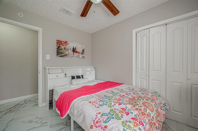 bedroom with a textured ceiling, visible vents, baseboards, marble finish floor, and a closet