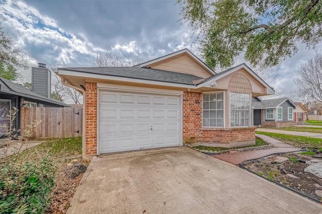 single story home featuring brick siding, a shingled roof, concrete driveway, an attached garage, and fence