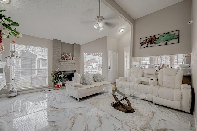 living area featuring a brick fireplace, marble finish floor, a healthy amount of sunlight, and a textured ceiling