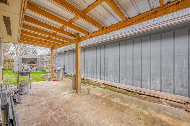 view of patio with a storage unit, an outdoor structure, and fence