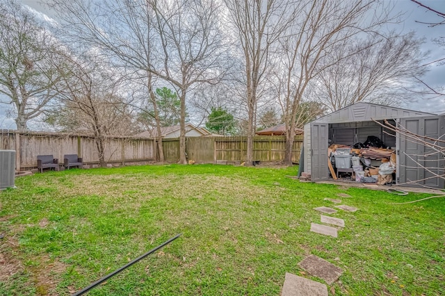 view of yard featuring a storage shed, an outdoor structure, and a fenced backyard