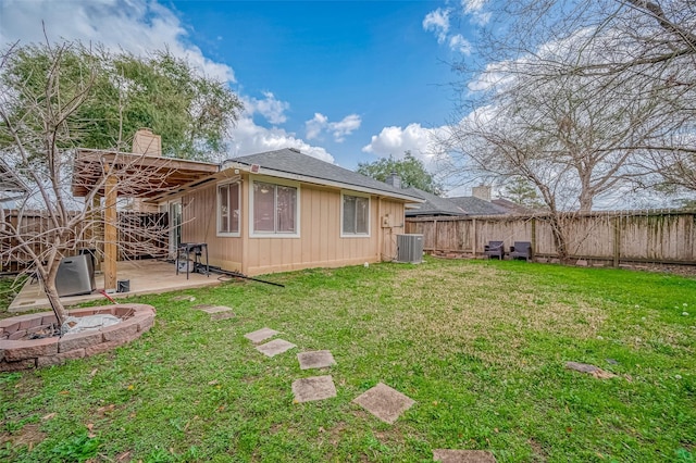 back of house featuring central AC unit, a chimney, fence private yard, a yard, and a patio area