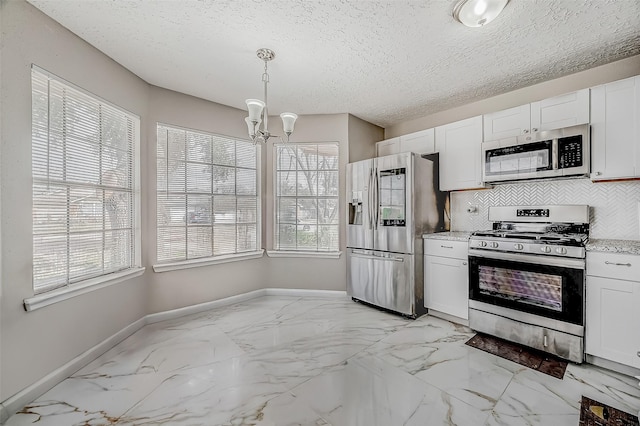 kitchen with baseboards, decorative backsplash, appliances with stainless steel finishes, a textured ceiling, and white cabinetry