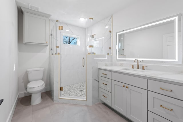 bathroom featuring vanity, toilet, and a shower with shower door