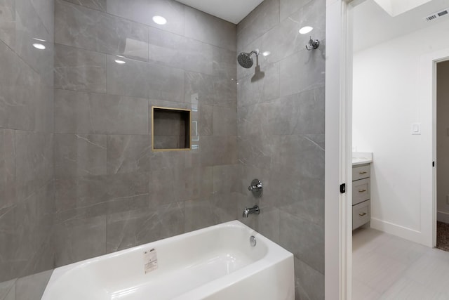 bathroom with vanity and tiled shower / bath