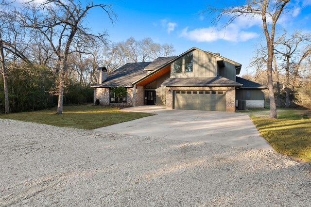 view of front of home featuring a garage, central AC unit, and a front lawn