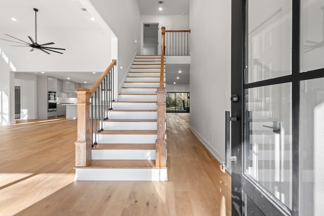 entryway featuring a high ceiling, ceiling fan, and light hardwood / wood-style floors