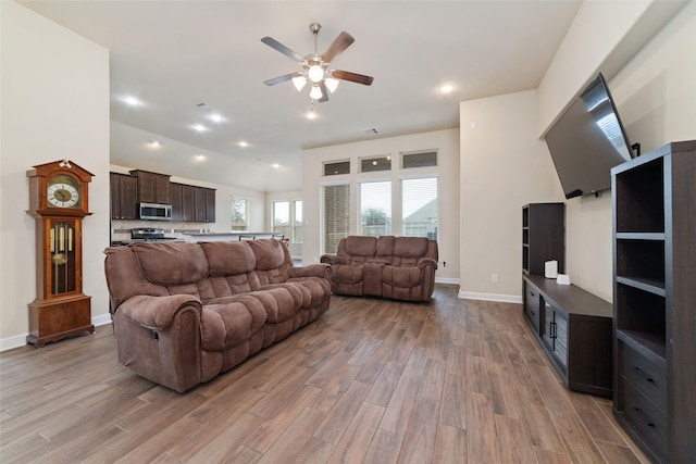 living room with ceiling fan and light hardwood / wood-style flooring