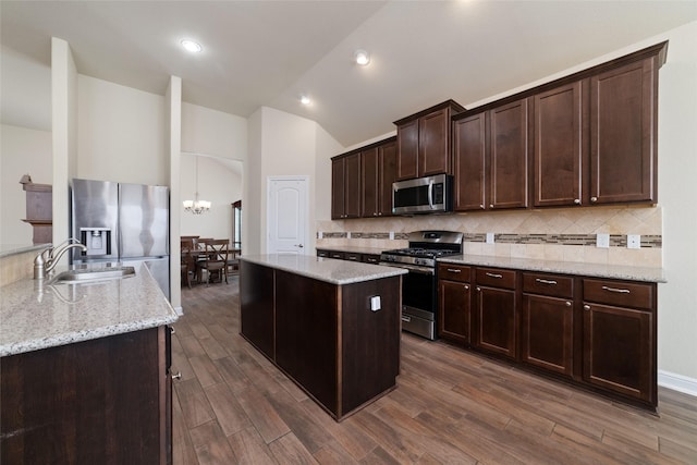 kitchen featuring stainless steel appliances, light stone countertops, sink, and dark brown cabinets