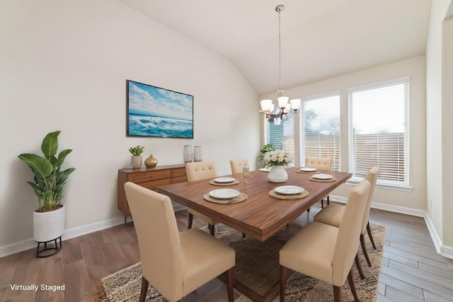 dining space featuring vaulted ceiling, baseboards, wood finished floors, and a chandelier