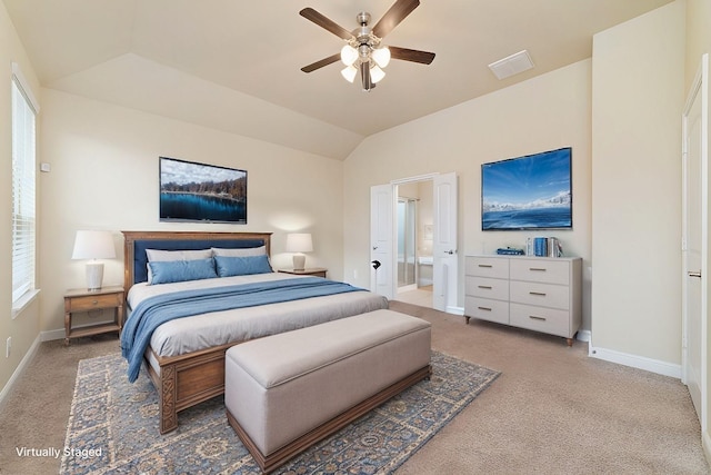 bedroom featuring connected bathroom, light carpet, vaulted ceiling, and baseboards