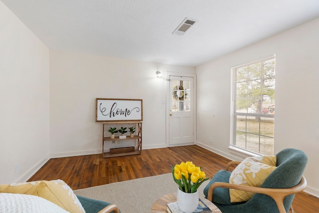 living room with a wealth of natural light and dark hardwood / wood-style flooring