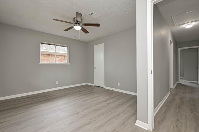 unfurnished room featuring ceiling fan, light hardwood / wood-style flooring, and a textured ceiling