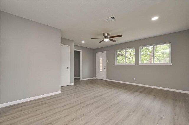 spare room with ceiling fan and light wood-type flooring