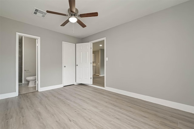 unfurnished bedroom featuring ceiling fan, ensuite bath, and light hardwood / wood-style flooring