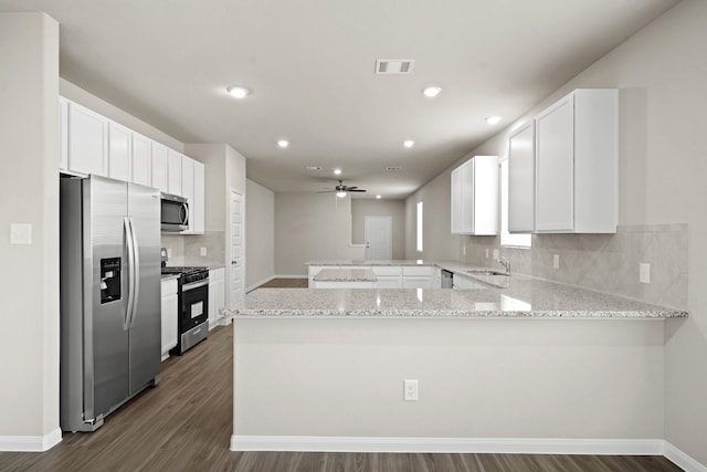 2331 E Chunk Dr, Conroe, TX 77301 - kitchen featuring light stone countertops, a peninsula, visible vents, a sink, and stainless steel appliances