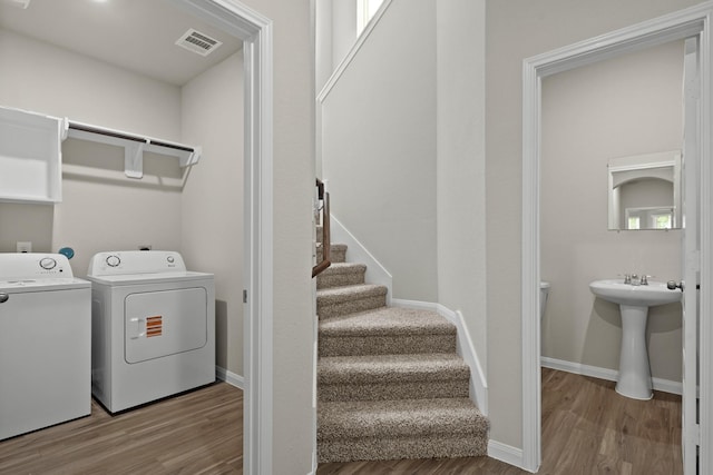 2331 E Chunk Dr, Conroe, TX 77301 - clothes washing area featuring baseboards, visible vents, washer and clothes dryer, laundry area, and wood finished floors