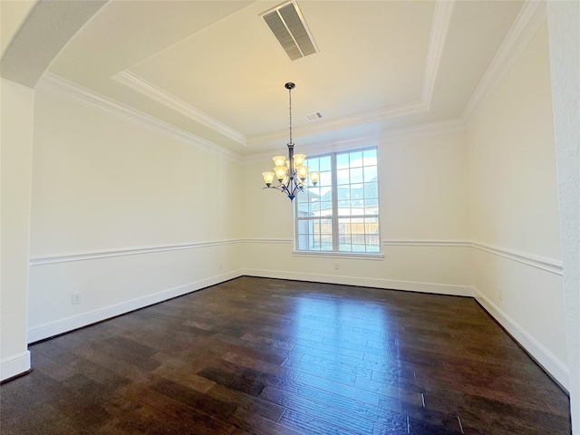 spare room featuring crown molding, a tray ceiling, dark hardwood / wood-style floors, and a chandelier