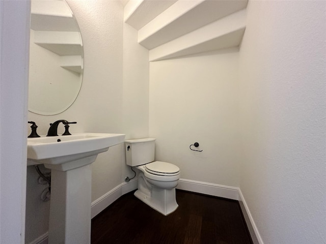 bathroom with hardwood / wood-style flooring and toilet