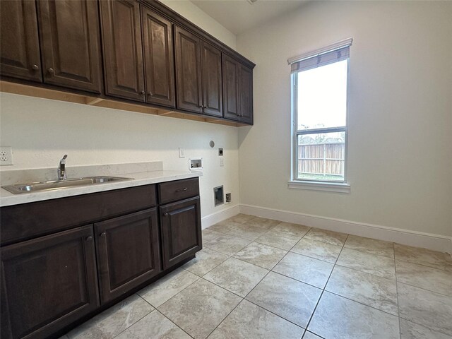 laundry area featuring sink, cabinets, light tile patterned floors, electric dryer hookup, and washer hookup