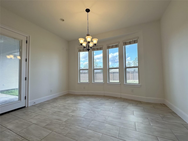 unfurnished room with a notable chandelier