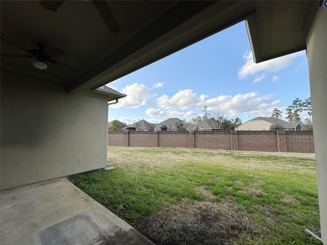 view of yard with ceiling fan and a patio area