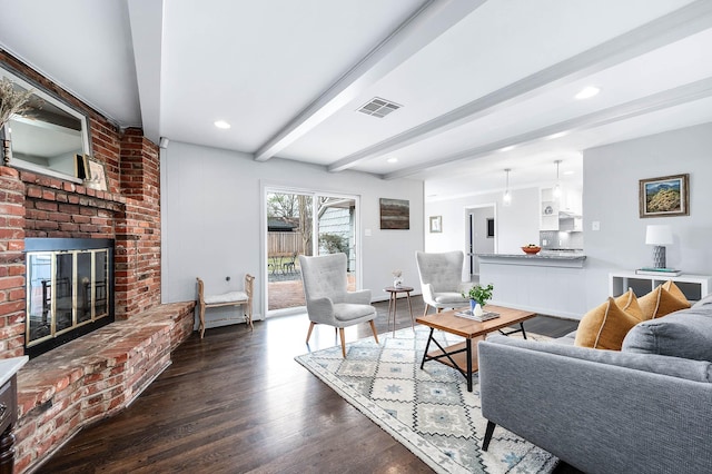 living room featuring dark hardwood / wood-style flooring, a fireplace, and beam ceiling