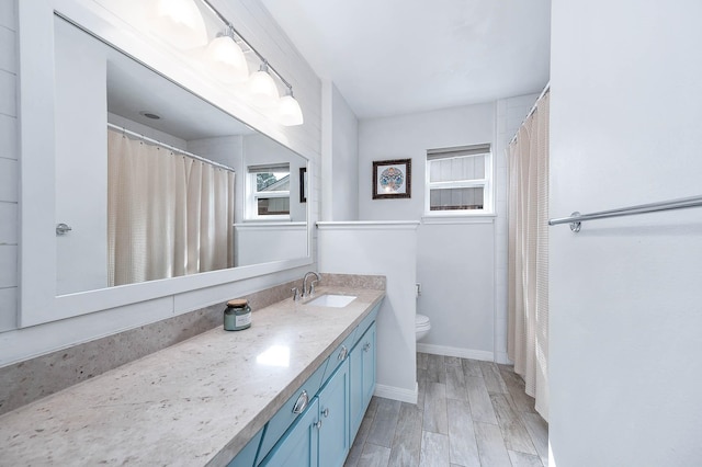 bathroom with vanity, hardwood / wood-style flooring, and toilet