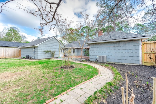 back of house featuring central AC and a lawn