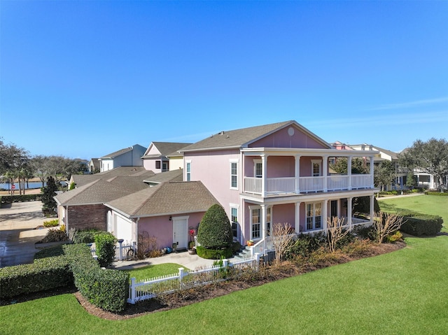 back of house with a yard and a balcony