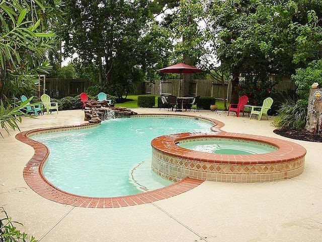 view of swimming pool featuring an in ground hot tub, pool water feature, and a patio area