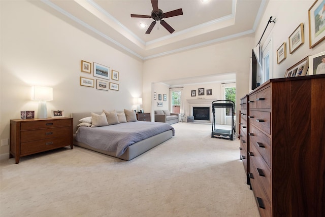 bedroom with a high ceiling, light colored carpet, access to exterior, a raised ceiling, and crown molding