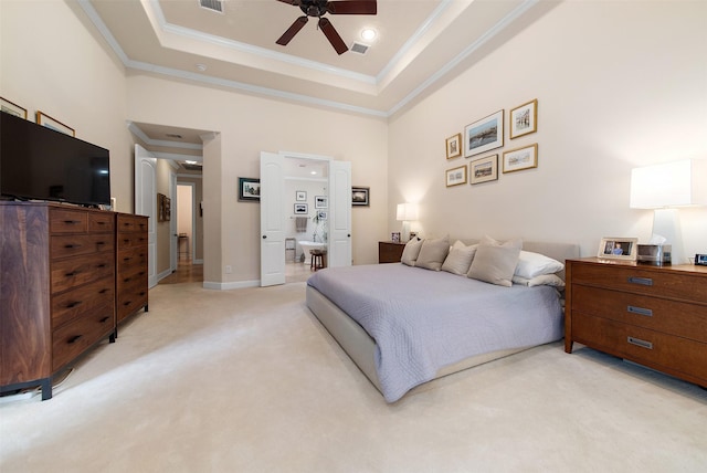 carpeted bedroom with ensuite bathroom, a high ceiling, ceiling fan, a tray ceiling, and crown molding