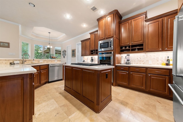 kitchen featuring sink, crown molding, stainless steel appliances, a tray ceiling, and decorative light fixtures