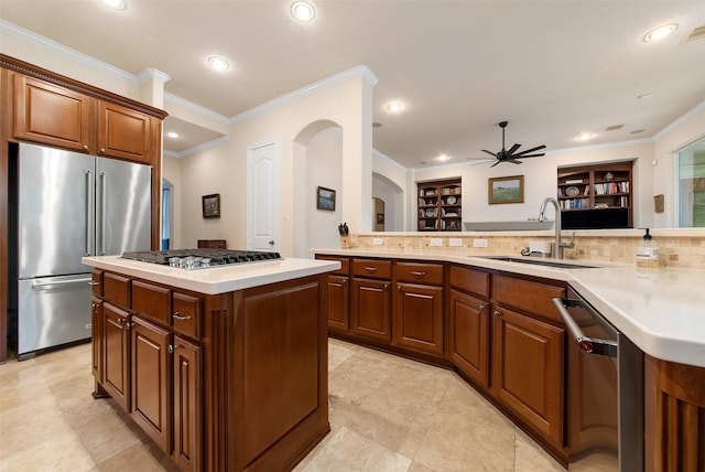 kitchen with sink, stainless steel appliances, kitchen peninsula, and a kitchen island