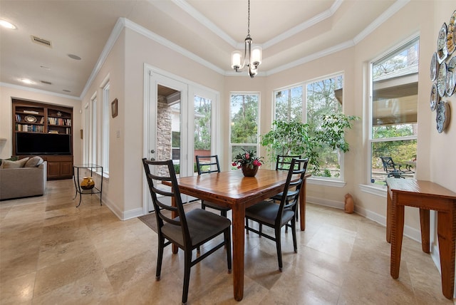 dining room featuring an inviting chandelier, crown molding, and a raised ceiling